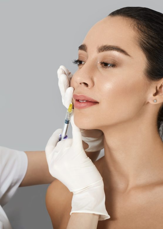 Beautician doing filler injection in female lips for woman's lip augmentation. Injections for